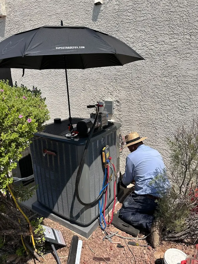 HVAC technician performing outdoor AC maintenance in Plainsboro